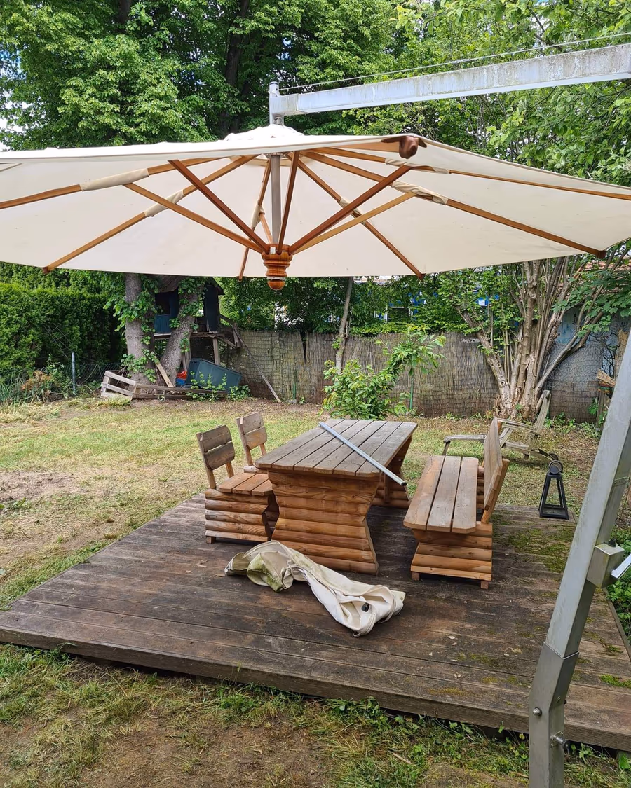 Dieselbe Gartenanlage in Straubing nach der Pflege durch G&N Transporte – aufgeräumte Terrasse mit Sitzgruppe