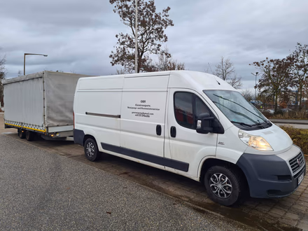 Der weiße Umzugswagen von G&N Transporte mit Anhänger bereit für einen Umzug in Straubing